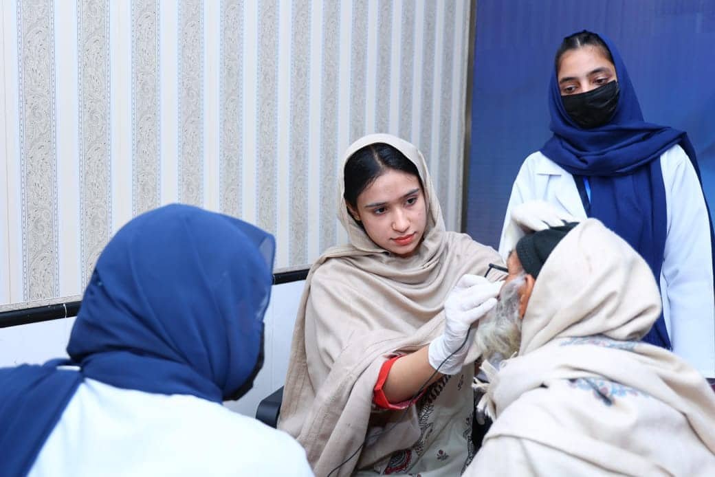Female medical staff examining elderly patient at the eye clinic