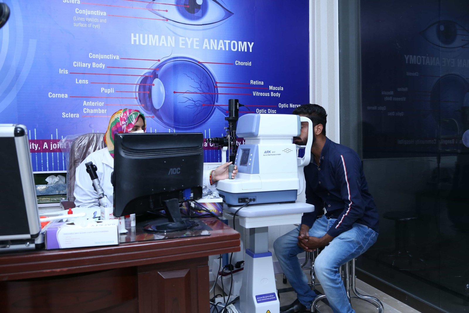 Patient undergoing eye examination with modern equipment and anatomy display