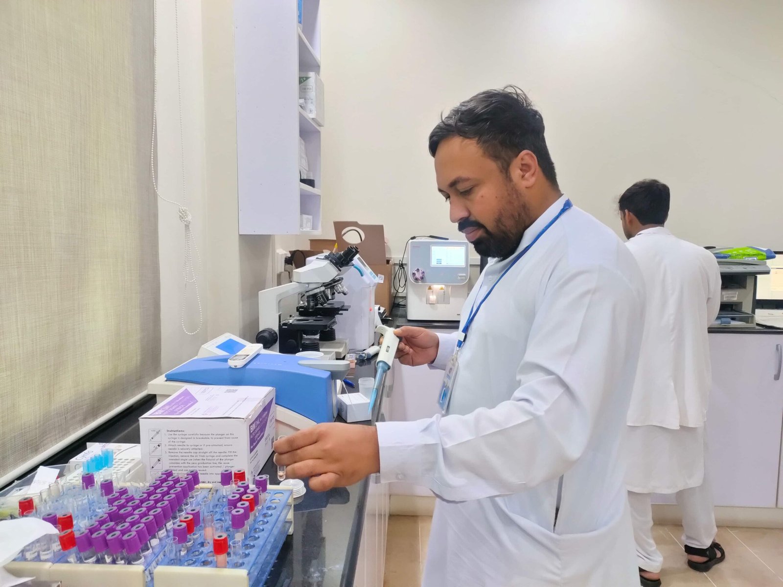 Lab technician working with microscope at the hospital laboratory