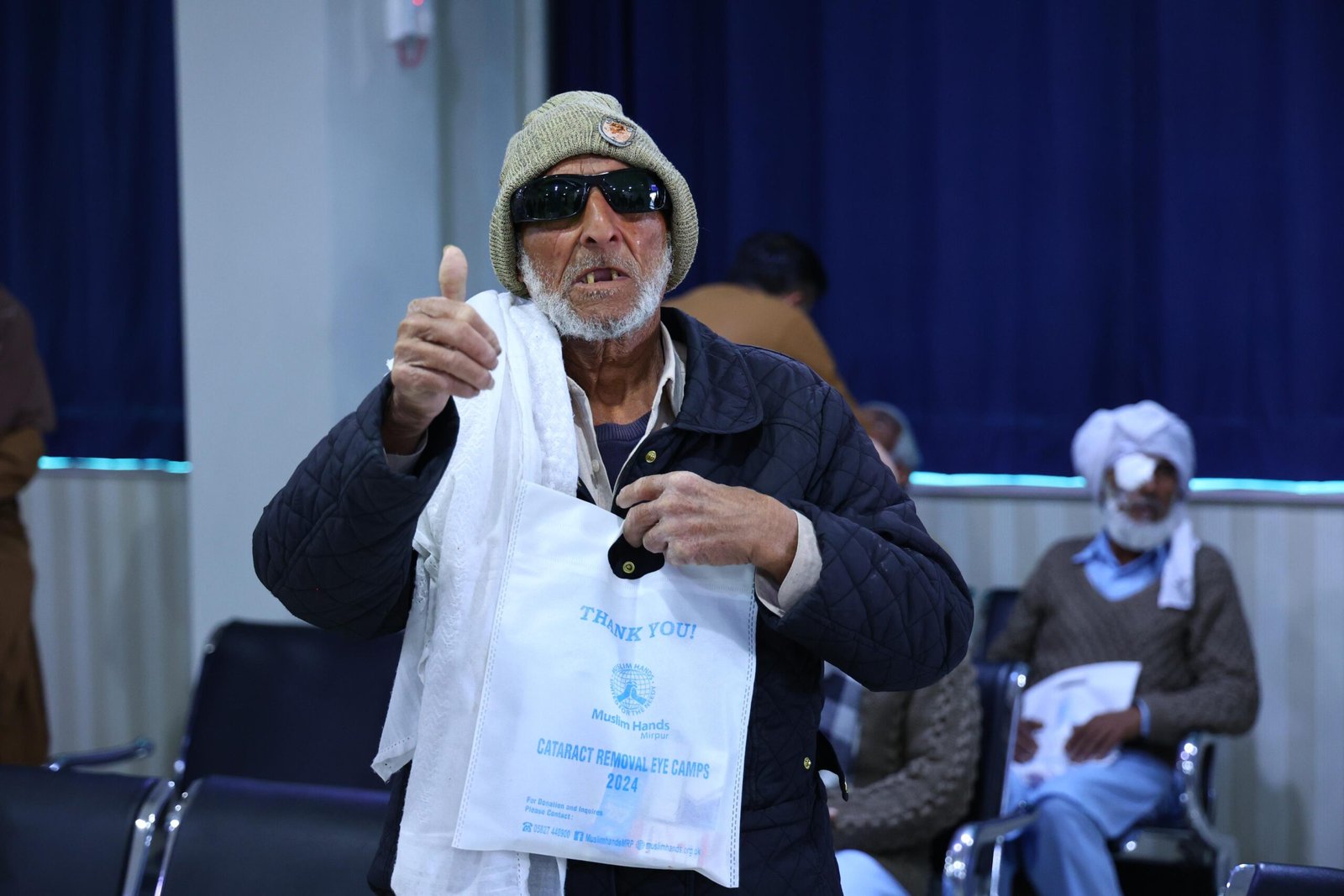 Grateful patient with thank-you card after cataract surgery camp